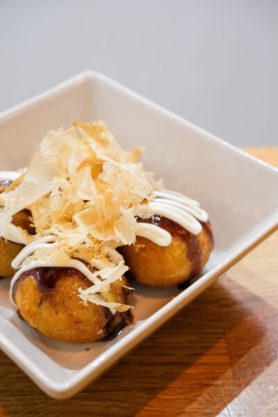 Cuatro bolas de pulpo takoyaki con escamas de atún secas