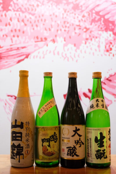 Cuatro botellas de sake de diferentes colores