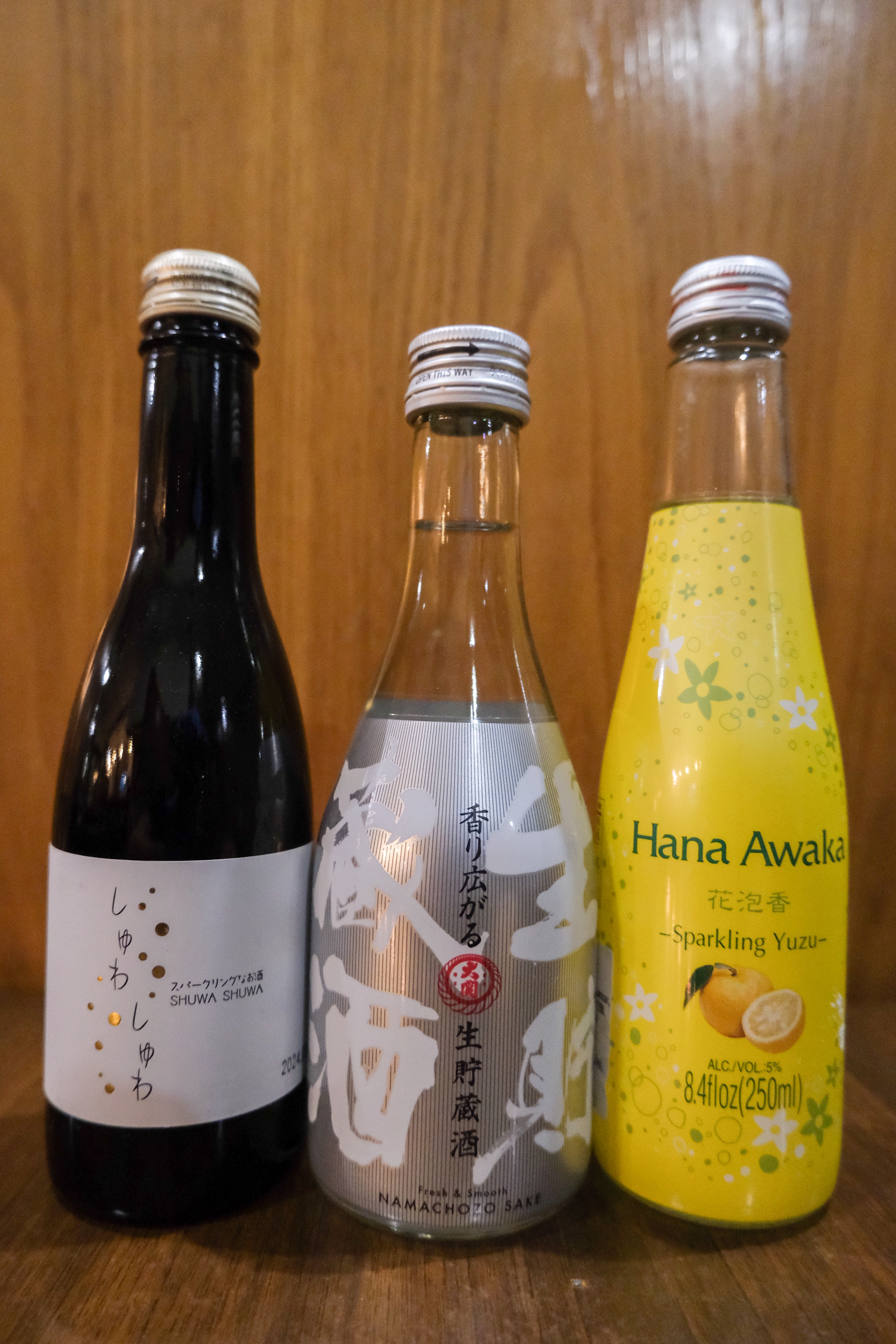 Tres botellas de sake y licores espumosos japoneses