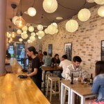 Sala de comedor de Restaurante Keitoku con clientes sentados y un camarero.